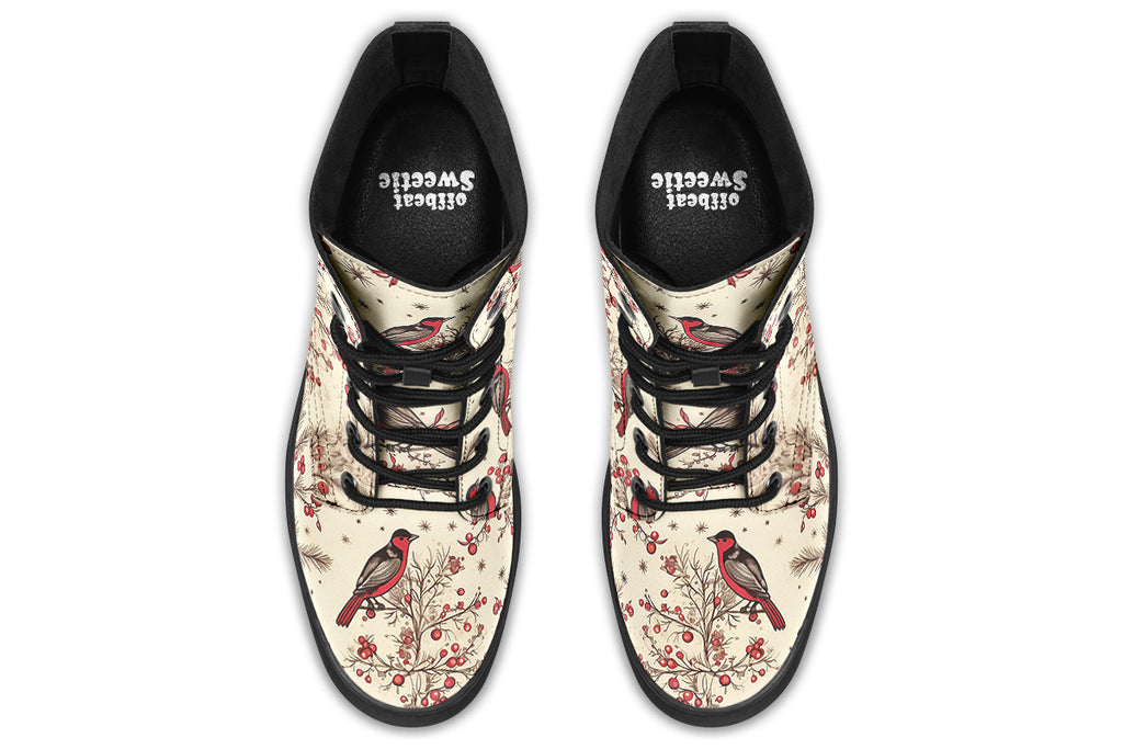 Cream coloured boots featuring images of brown tree branches with red berries, and red and black birds sitting on the branches.