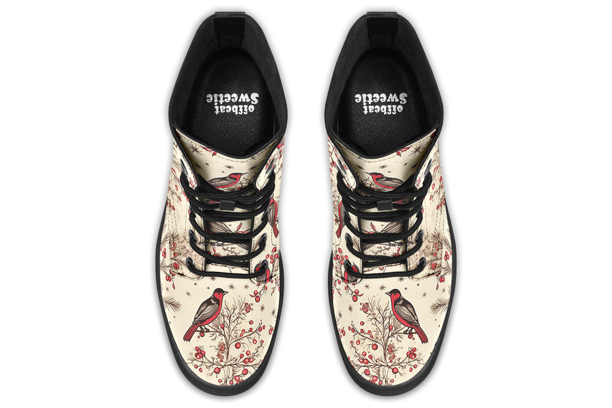 Cream coloured boots featuring images of brown tree branches with red berries, and red and black birds sitting on the branches.