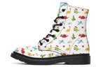 White boots featuring a pattern of different dinosaurs in Christmas hats and scarves. Some are holding gifts.