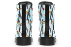 Light blue boots with a repetitive penguin pattern all over them.