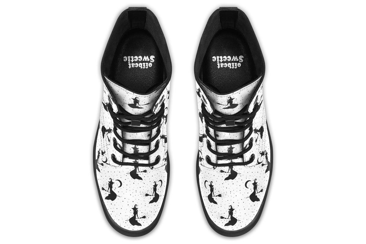 White boots with a repetitive black pattern of the silhouettes of witches on broomsticks