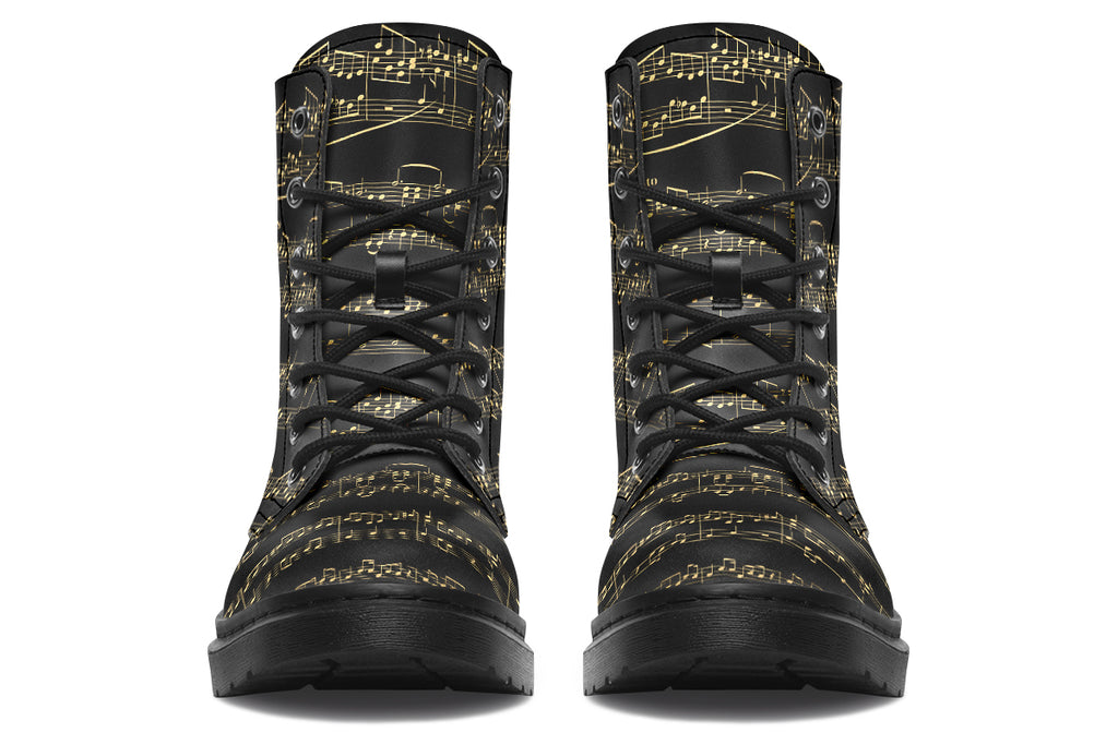 Black boots with a black sole, featuring yellowish/gold sheet music design.