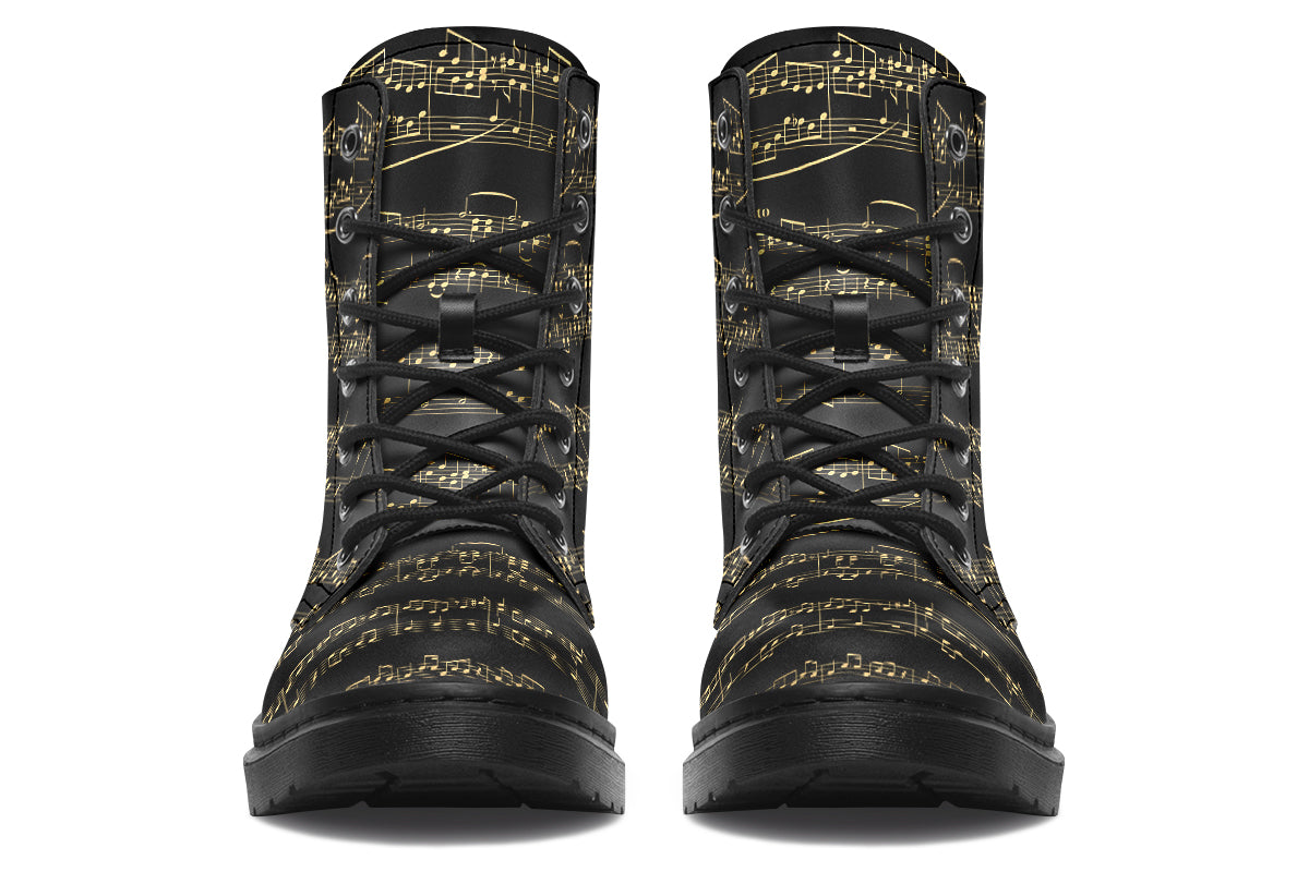 Black boots with a black sole, featuring yellowish/gold sheet music design.