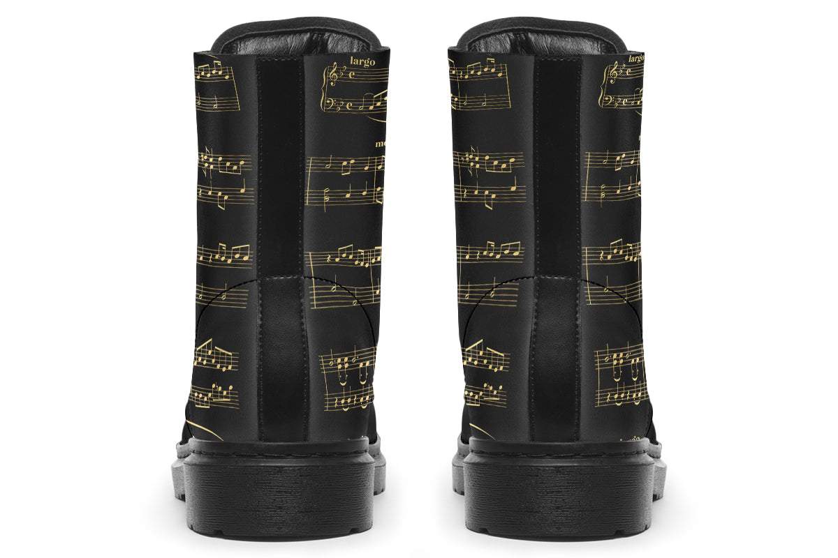 Black boots with a black sole, featuring yellowish/gold sheet music design.