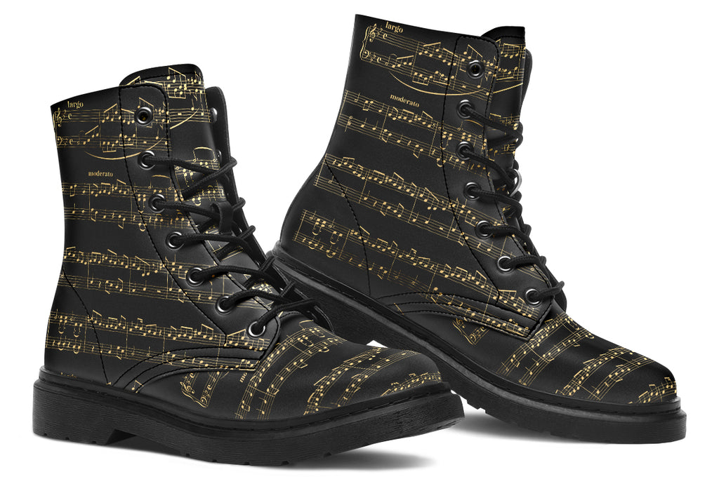 Black boots with a black sole, featuring yellowish/gold sheet music design.