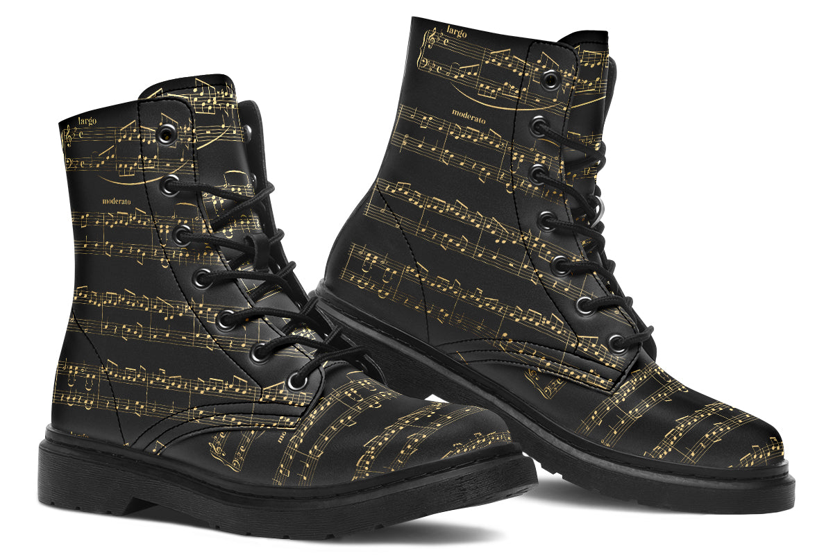 Black boots with a black sole, featuring yellowish/gold sheet music design.