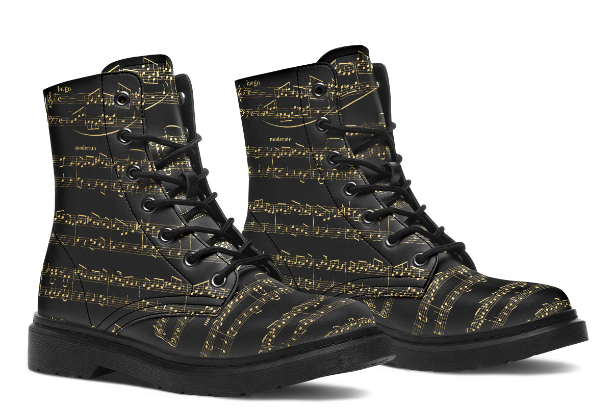 Black boots with a black sole, featuring yellowish/gold sheet music design.