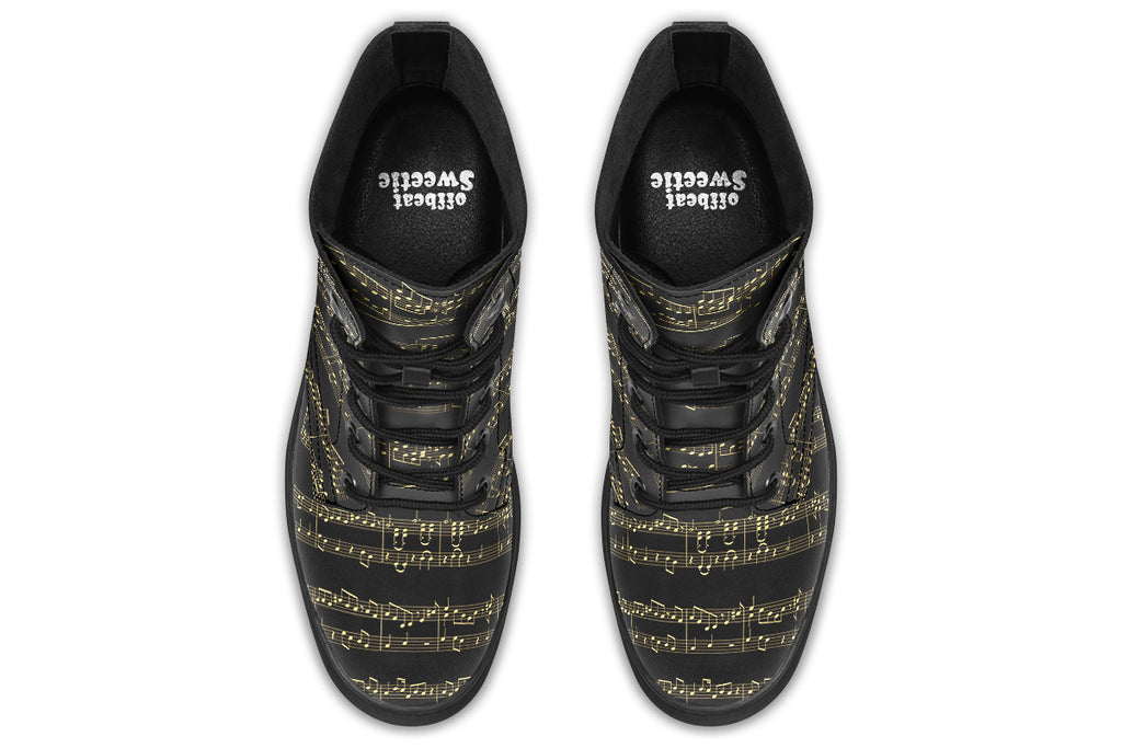 Black boots with a black sole, featuring yellowish/gold sheet music design.