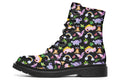 Black boots featuring a patterns of pink and purple dinosaurs, rainbows and plants.