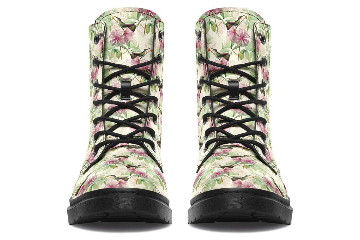 Cream-coloured boots with a pattern of dark green hummingbirds, pink flowers and green leaves