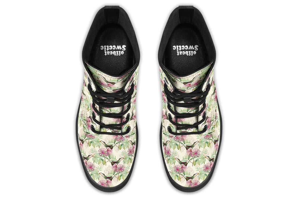 Cream-coloured boots with a pattern of dark green hummingbirds, pink flowers and green leaves