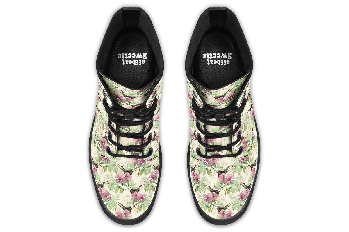 Cream-coloured boots with a pattern of dark green hummingbirds, pink flowers and green leaves