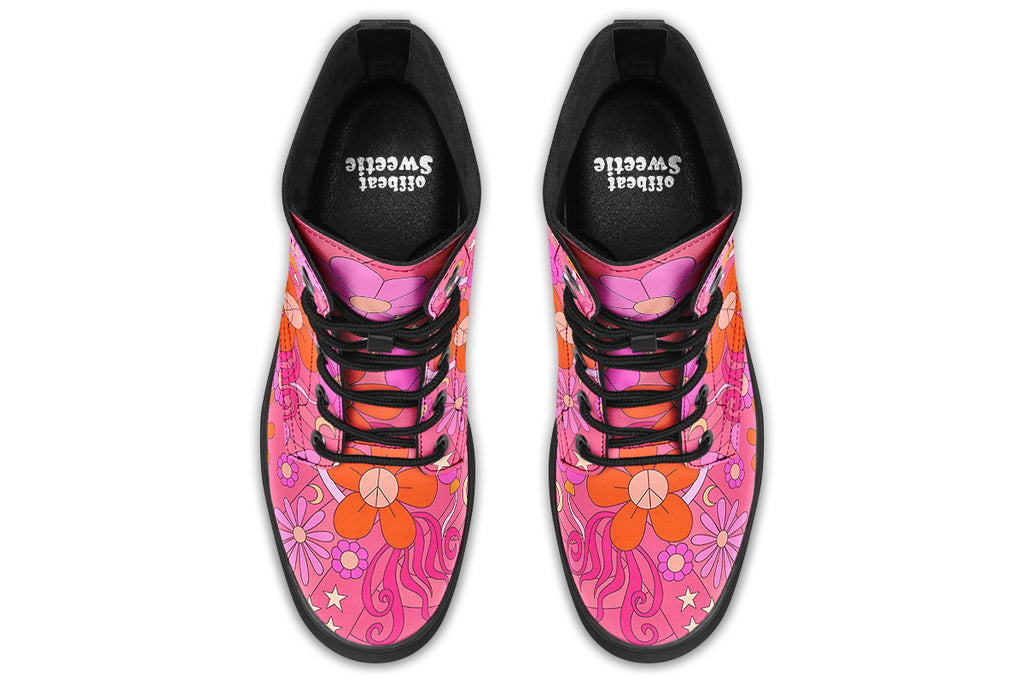 Pink boots with a black sole. Pattern shows midcentury retro-style daisies and decorative swirls.