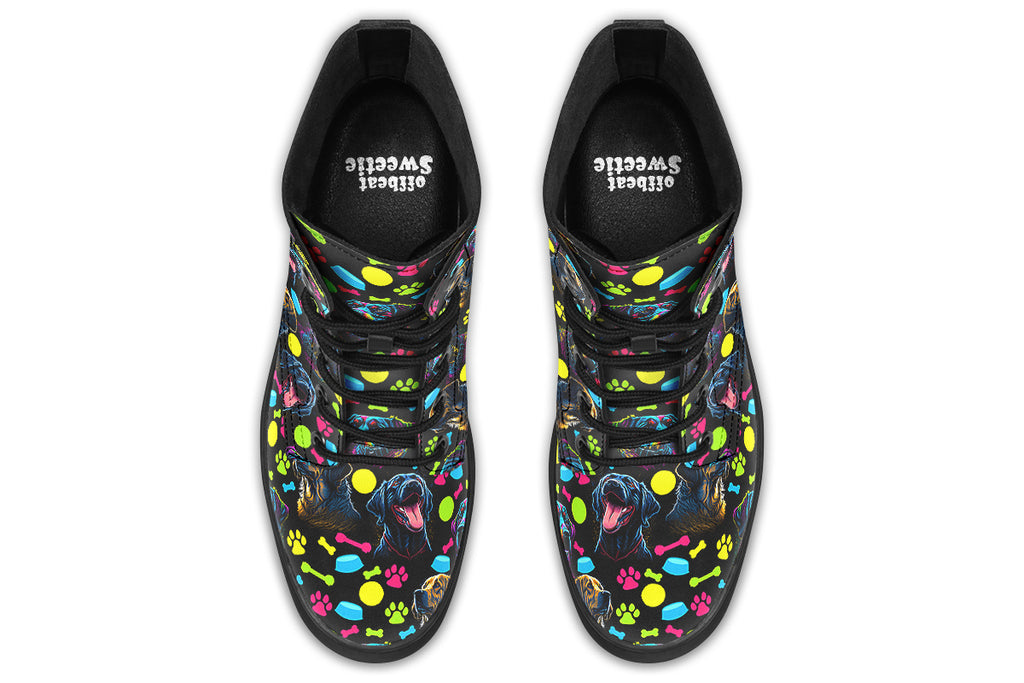 Black boots with a repetitive pattern of dog faces and neon paw prints, dog bowls and dog bones.