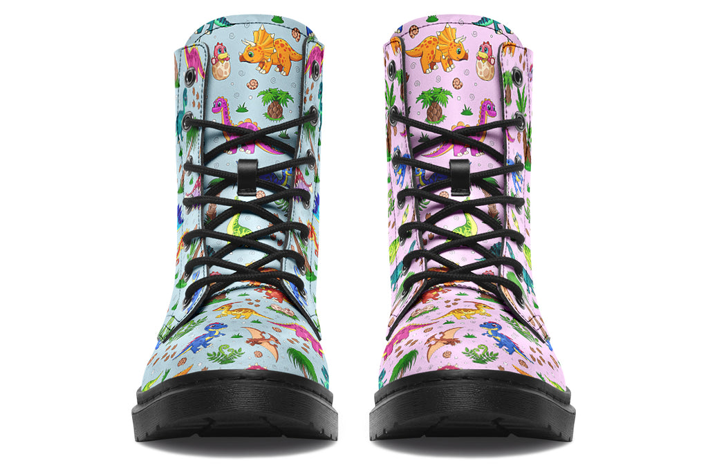 Mismatched boots, one light blue, one light pink, each with a pattern of different coloured cute baby dinosaurs, prehistoric-looking trees and dinosaur eggs