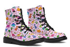 Light pink boots with a pattern of different coloured cute baby dinosaurs, prehistoric-looking trees and dinosaur eggs