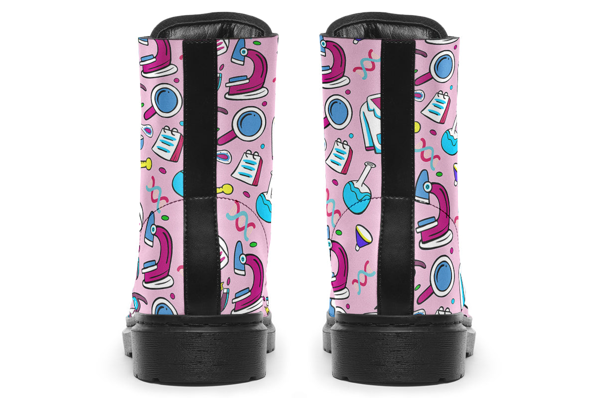 Pink boots featuring a pattern of various STEM icons, such as microscopes, lab coats, DNA helix, microscopes, gloves and beakers. 