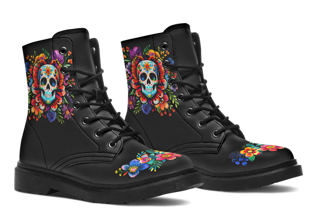 Black boots with a sugar skull design on each side, with a floral and dotted pattern on the skull and different colours flowers coming out from behind the skull. The toes of the boots feature a matching flower design.