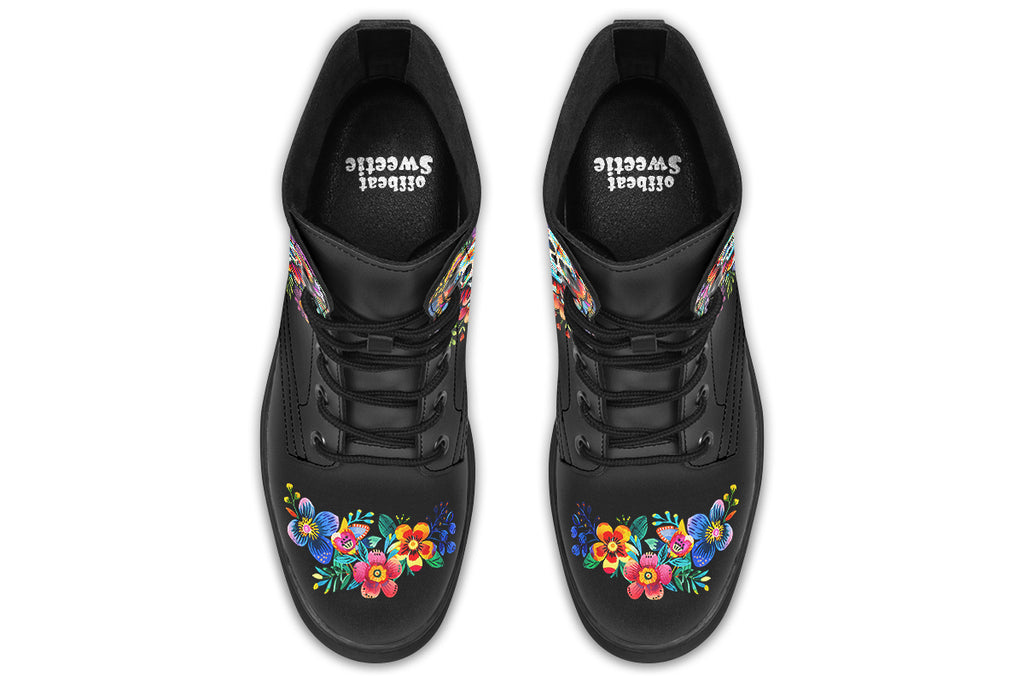 Black boots with a sugar skull design on each side, with a floral and dotted pattern on the skull and different colours flowers coming out from behind the skull. The toes of the boots feature a matching flower design.