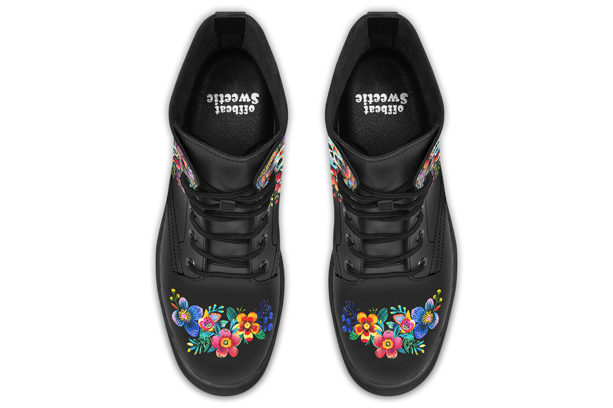 Black boots with a sugar skull design on each side, with a floral and dotted pattern on the skull and different colours flowers coming out from behind the skull. The toes of the boots feature a matching flower design.