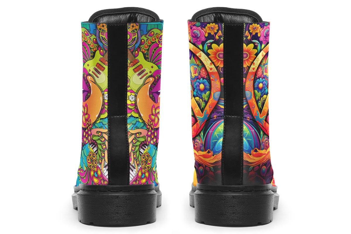 Vibrant, colourful mismatched boots in a design that’s reminiscent of a midcentury psychedelic album cover. The right boot features a peace sign with a flower-patterned guitar in it, surrounded by colourful flowers, a second guitar and other decorative patterns. The left boot features pink lips with a long tongue coming out of them which almost looks like it is licking the guitar next to it. The design has another guitar down the bottom and a busy pattern of colourful florals and swirls.