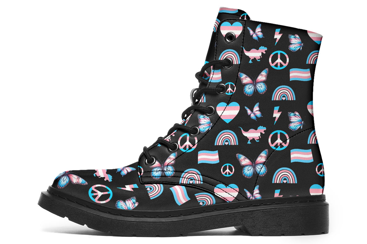 Black boots featuring a pattern of various icons in the trans flag colours, such as hearts, rainbows, peace signs, flags, butterflies and dinosaurs.