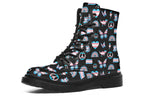Black boots featuring a pattern of various icons in the trans flag colours, such as hearts, rainbows, peace signs, flags, butterflies and dinosaurs.