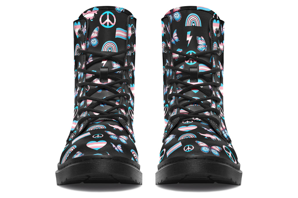 Black boots featuring a pattern of various icons in the trans flag colours, such as hearts, rainbows, peace signs, flags, butterflies and dinosaurs.