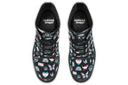 Black boots featuring a pattern of various icons in the trans flag colours, such as hearts, rainbows, peace signs, flags, butterflies and dinosaurs.