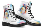 White boots with an image of a penguin on the sides, in the style of a watercolour painting with various colours splashed behind the penguin and on the toes and tongue of the boots