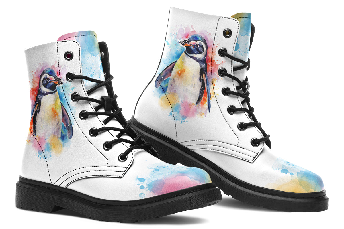 White boots with an image of a penguin on the sides, in the style of a watercolour painting with various colours splashed behind the penguin and on the toes and tongue of the boots