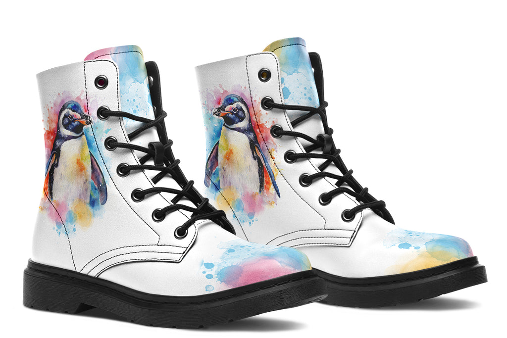 White boots with an image of a penguin on the sides, in the style of a watercolour painting with various colours splashed behind the penguin and on the toes and tongue of the boots