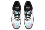 White boots with an image of a penguin on the sides, in the style of a watercolour painting with various colours splashed behind the penguin and on the toes and tongue of the boots