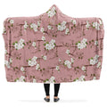 Hooded blanket with a white floral pattern on a pink background