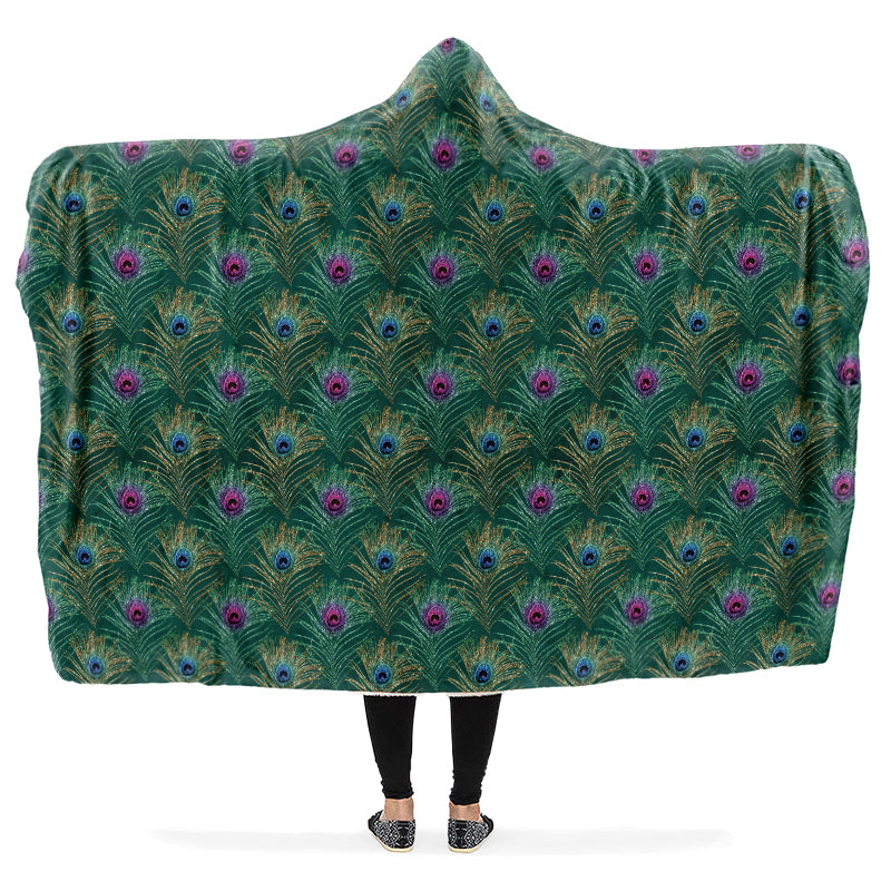 Person wearing a green peacock feather patterned hooded blanket
