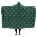 Person wearing a green peacock feather patterned hooded blanket