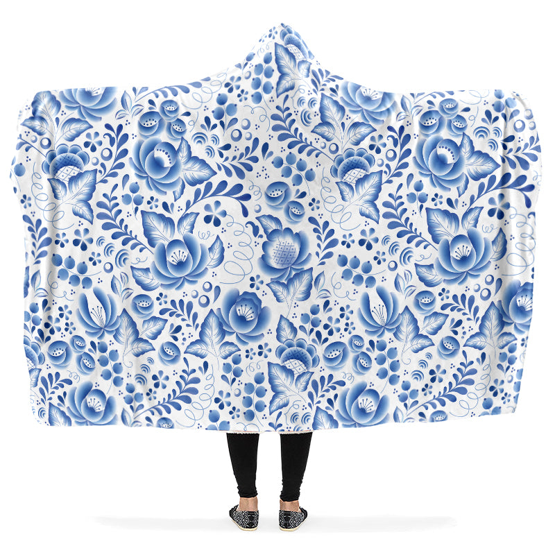 Person holding a floral patterned blue and white hooded blanket