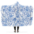 Person holding a floral patterned blue and white hooded blanket