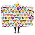 Hooded blanket with various pride flags in the shapes of hearts on a white background.