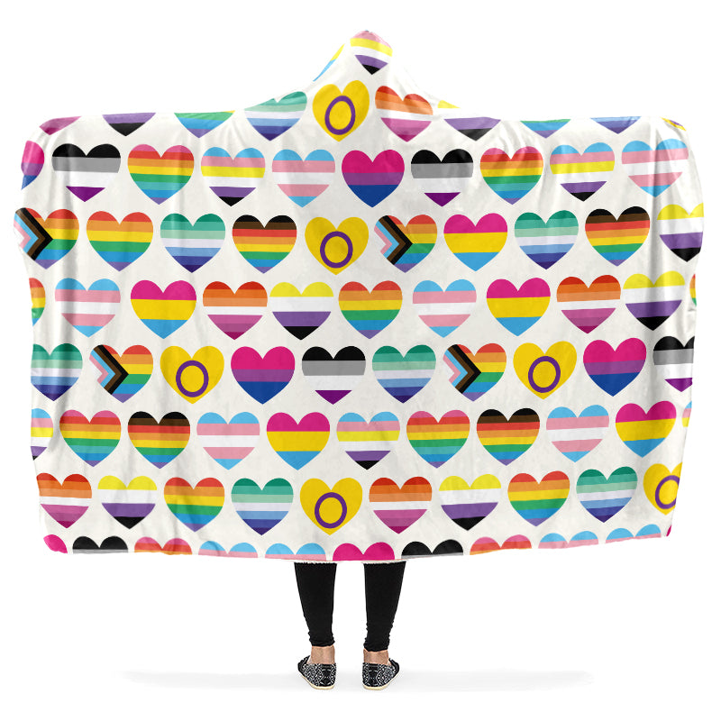 Hooded blanket with various pride flags in the shapes of hearts on a white background.