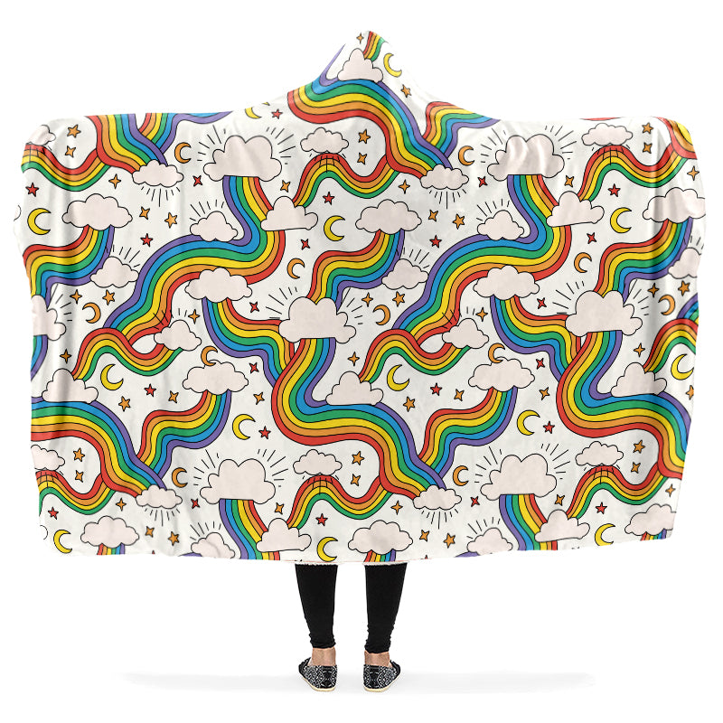 Person holding a colorful rainbow-patterned hooded blanket with clouds and stars.