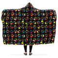 Hooded blanket with colorful paw print pattern on a black background