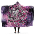 Hooded blanket with a colorful design of music notes, guitars, sheet music etc on a purple and pink gradient background.