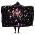 Black hooded blanket with galaxy design worn by a person with arms outstretched.