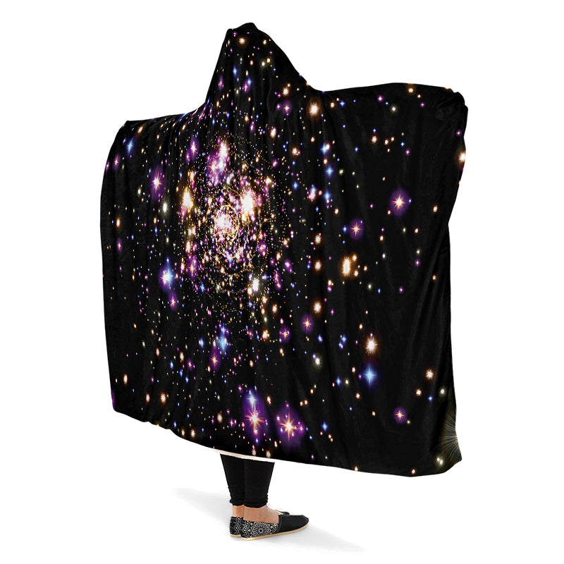Black hooded blanket with galaxy design worn by a person with arms outstretched.