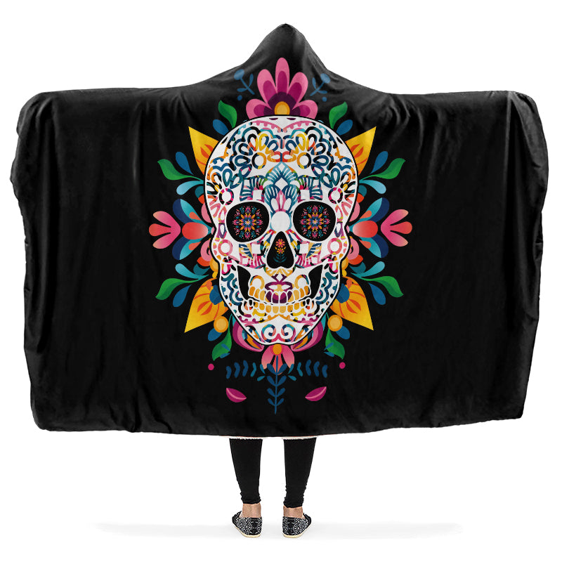 Black hooded blanket with a colorful skull design, being worn by a person with arms outstretched.