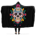 Black hooded blanket with a colorful skull design, being worn by a person with arms outstretched.