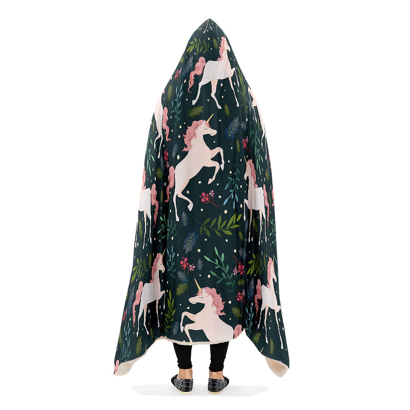 Hooded blanket with white and pink unicorn and leaves pattern on a dark green background.