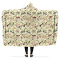 Hooded blanket with dragonfly and floral pattern being worn by a person with arms outstretched.