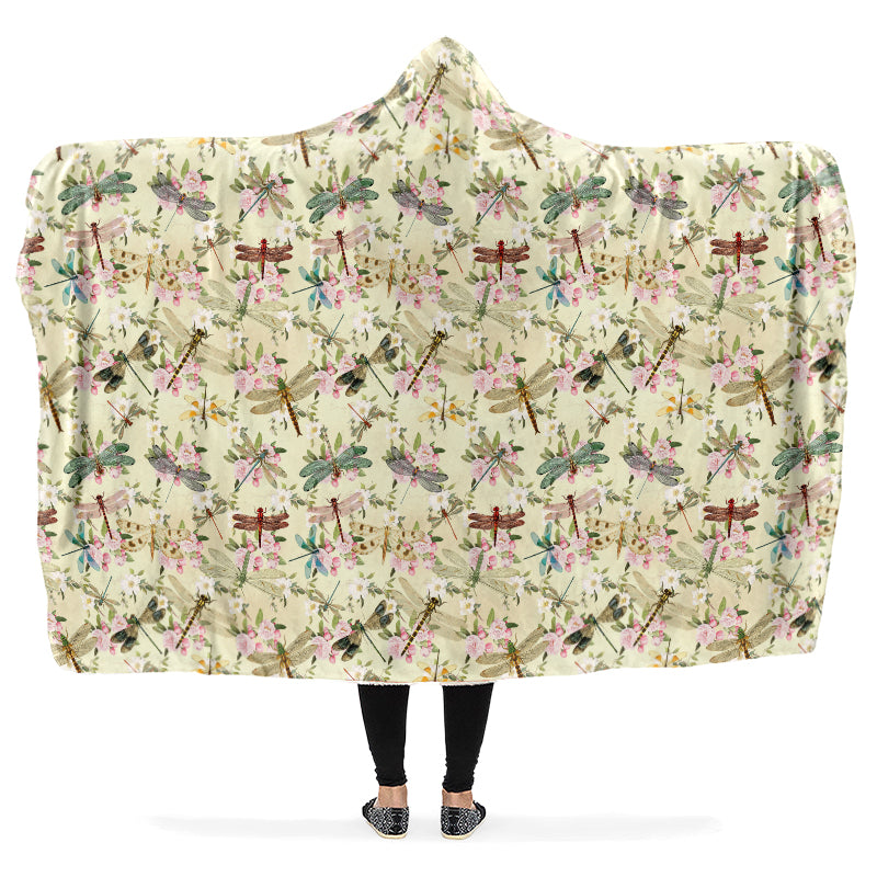 Hooded blanket with dragonfly and floral pattern being worn by a person with arms outstretched.